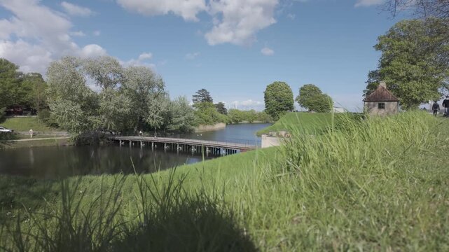 Rampart grass framing the moat and footbridge at Kastellet