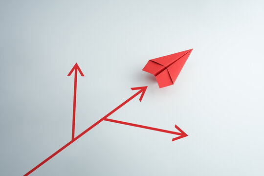 Red paper plane choosing a path at a junction of red arrows, business decision and direction concept