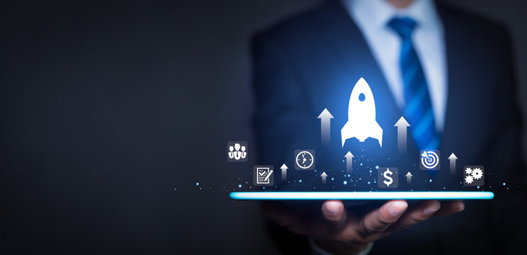 Corporate innovation and success concept with businessman holding tablet with rocket taking off and business icons