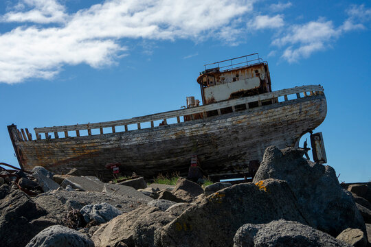 Old abandoned wooden shipwreck Hofrungur AK 91 on the rocky coastline of Akranes, Iceland.
