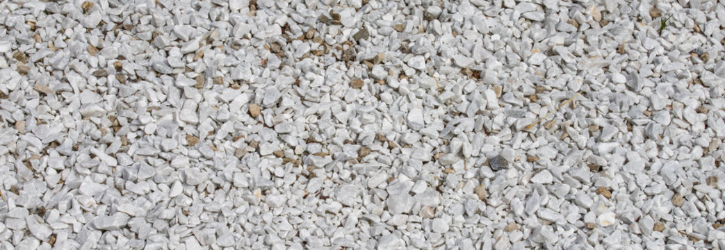 White crushed gravel ground surface texture background with small stones