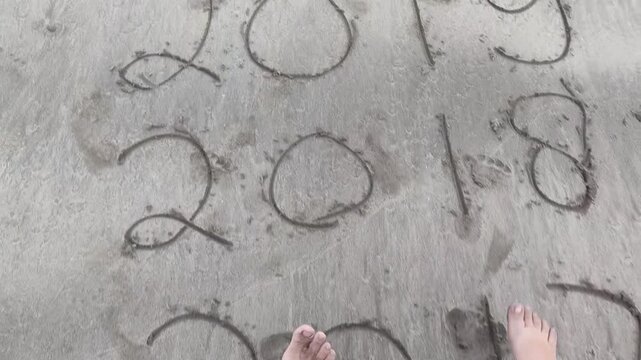 Video Clip of 2014 until 2022 Years Written in the Sand on a Beach
