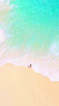 Top Down Drone View Of Person At Shoreline With Turquoise Waves