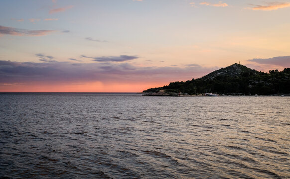 Golden sunset paints calm ocean waters.