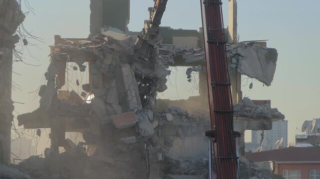Excavator with hydraulic crusher is tearing down the old typical Turkish multi-storey apartment, residential building in Istanbul, Turkey - demolition of building, slow motion