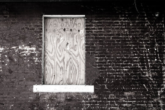 La finestra di una casa abbandonata chiusa con una tavola di legno