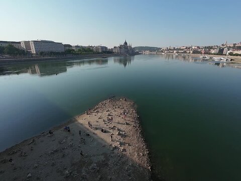 Low water level of the Danube river in Budapest at sunrise, featuring the Liberty Bridge and the uncovered Inseg Rock, and the Margit bridge and the island. 02.08.2026.