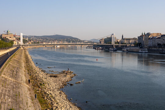 Low water level of the Danube river in Budapest at sunrise, featuring the Liberty Bridge and the uncovered Inseg Rock, and the Margit bridge and the island. 02.08.2026.