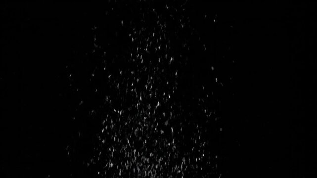White dust particles falling on black background