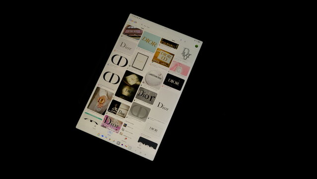 Tablet screen view with various sized Dior logos, on a black background, August 1, 2026