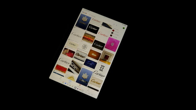 Tablet screen view with various sized Cartier logos, on a black background, August 1, 2026	
