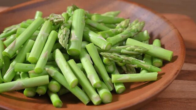 Fresh Green Asparagus on Wooden Plate
