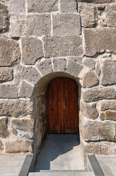 Architectural detail of an old wooden door framed by a historical stone archway at Kayseri Castle, Kayseri, Turkey