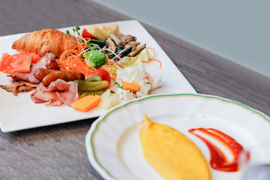 オムレツと豪華な朝食プレートが並ぶホテルモーニングのテーブル