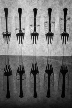 Abstract still life with forks in glass goblets filled with liquid