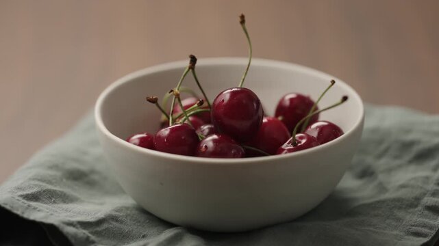 Slow motion man hand picking fresh cherries from white bowl