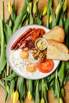 English breakfast on a vintage plate against a tulip background, isolated. Professional studio lighting. Top view.
