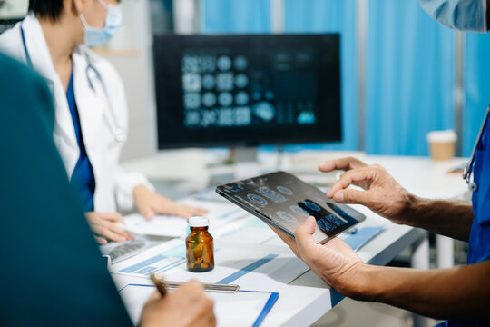 Asian medical team discusses virus research, vaccine development and infectious disease strategy using digital healthcare data during a clinical meeting.