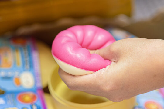 Squishy toys, Closeup child teen girl hand squeeze play pressing soft foam toy for stress relief
