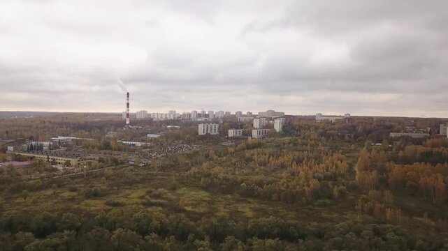 Drone approaching Pushchino town over autumn trees