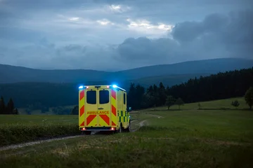 Emergency medical service ambulance vehicle driving on mountain road during twilight. Remote area rescue mission, urgent healthcare response and medical transport concept. © Chalabala