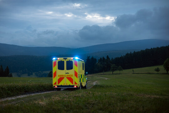 Emergency medical service ambulance vehicle driving on mountain road during twilight. Remote area rescue mission, urgent healthcare response and medical transport concept.