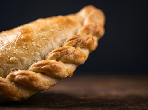 Macro detail of handcrafted Chilean empanada repulgue with flaky baked texture