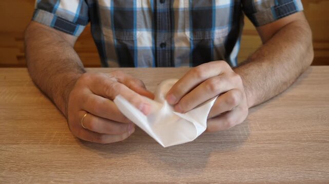 A man crumples soft plastic packaging material in his hands, creating a distinctive rustling sound. The video contains clean original audio.
