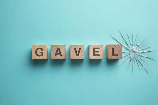 Wooden Blocks Spelling Gavel Next To A Shattered Glass Surface Representing Legal Breakdown And Judicial System Challenges