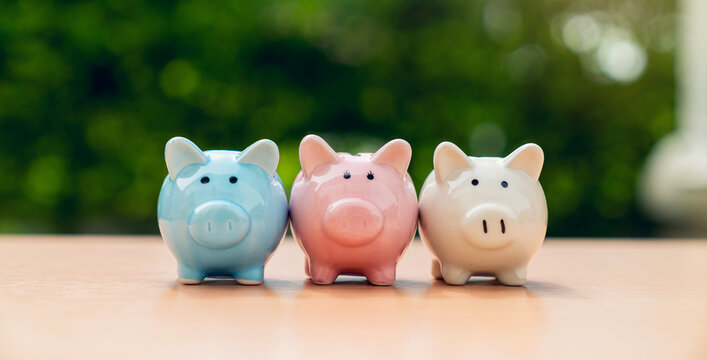 Three piggy banks on table with green nature background, Save money for prepare retirement concept.