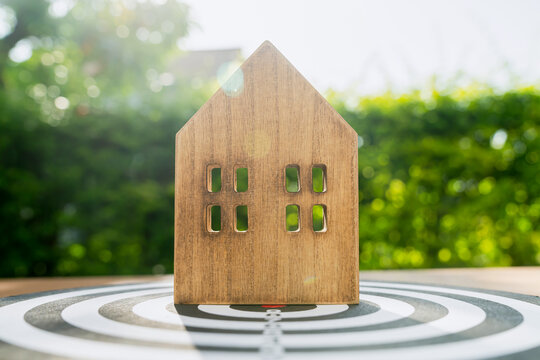 Wood house on table, concept of building a home to achieve a goal.