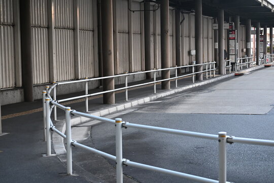 バス乗降場の白い安全柵と舗装路
