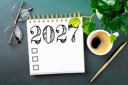 New year resolutions 2027 on desk. 2027 resolutions list with notebook, coffee cup on table. Goals, resolutions, plan, action, checklist concept. New Year 2027 template, copy space