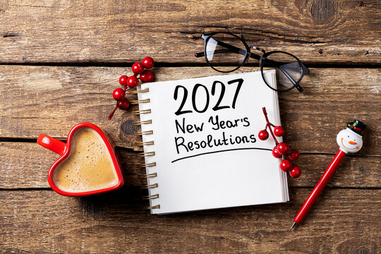 New year resolutions 2027 on desk. 2027 goals list with notebook, coffee cup on wooden table. Resolutions, plan, goals, action, checklist, idea concept. New Year 2027 resolutions, copy space