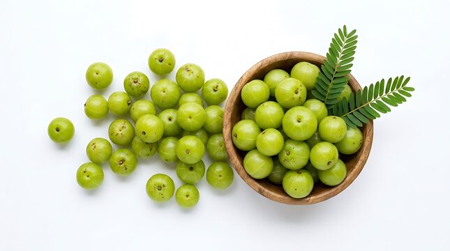 Fresh indian gooseberry amla fruits in a wooden bowl and scattered on a white background top view