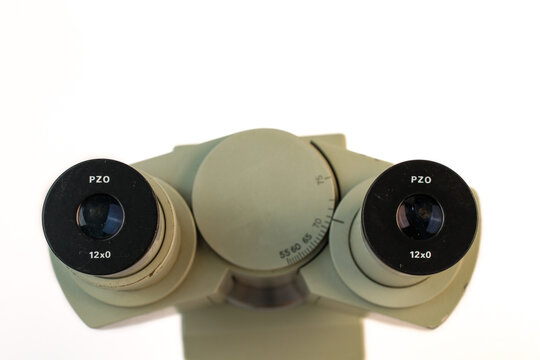 Close-up top view of binocular microscope eyepieces with interpupillary distance adjustment. Professional optical laboratory equipment isolated on a white background.