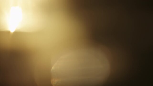 Slow motion real lens flare from back sunlight over dark background for overlay
