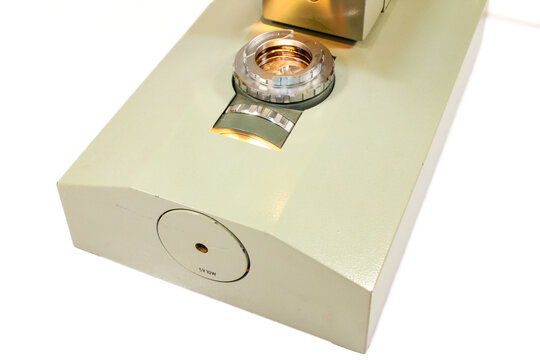 Macro detail of a microscope base with built-in light source and optical illuminator used for laboratory research, biology and education.