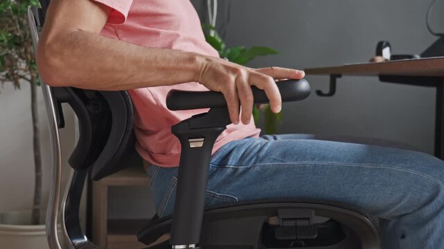 Man Adjusting Armrest on Ergonomic Office Chair