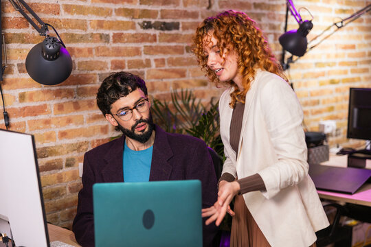 Colleagues working together on laptop in modern office