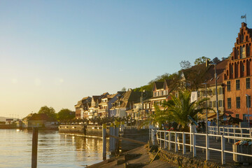 Obraz premium Golden Hour along Meersburg Promenade with Historic Waterfront and Palm Trees on Lake Constance