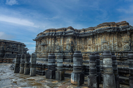 Intricately carved exterior of the Chennakeshava Temple in Belur, Karnataka, India, under a dramatic blue sky. Perfect for travel, heritage, architecture, culture, tourism, history, and editorial use.