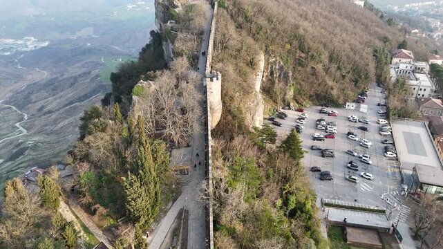 Aerial pan up and drone flyover of historic Falesia Second Tower peak in San Marino