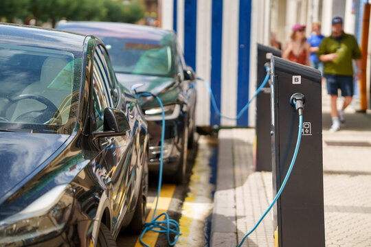 Row of electric vehicles charging at a outdoor public EV station in the city