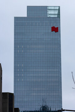 MONTREAL, CANADA, 24 December 2025 : modern skyscraper urban architecture reflective glass facade red logo overcast sky