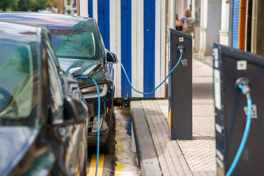 Row of electric vehicles charging at a outdoor public EV station in the city