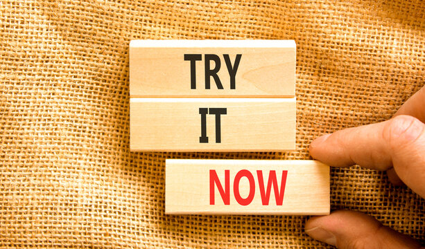 Try it now words symbol. Concept words Try is now on beautiful wooden blocks. Beautiful canvas background. Businessman hand. Business support motivational and try is now concept. Copy space.