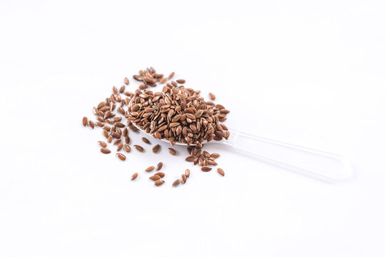 Brown flax seed on white background.