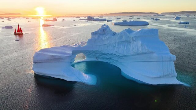 Aerial view of a massive Arctic ice floe revealing its hidden underwater structure. A solitary ice tower rises above the surface, showcasing the scale and mystery of polar ice.