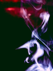Obraz premium Abstract Colorful Incense Smoke Curling Against Dark Background, Ethereal Smoke Art